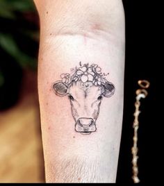 a cow with flowers on it's head is shown in this tattoo style photo