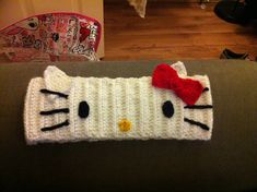 a crocheted hello kitty headband with a red bow on the top and bottom