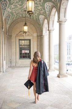 a woman in a red dress is walking down the street with her coat over her shoulders