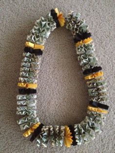 a necklace made out of glass beads with yellow and black ribbons on the end of it