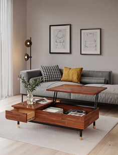 a living room with a couch, coffee table and two pictures on the wall above it