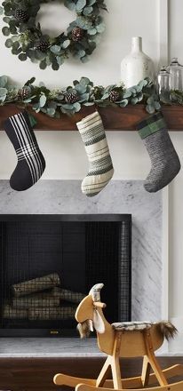 a rocking horse and christmas stockings hanging from a mantel