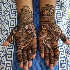 two hands with henna tattoos on them