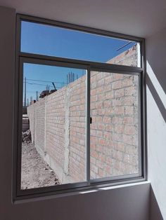 an open window in a room with brick walls and construction equipment on the other side