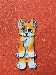 an orange and white cat sticker sitting on top of a red surface