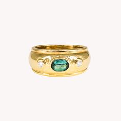 a gold ring with a green stone and two diamonds on the side, against a white background