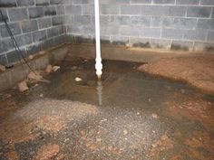 a drain in the ground with water coming out of it and some rocks on the floor