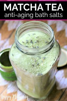 a jar filled with green bath salts sitting on top of a wooden table