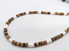 Natural and earthy genuine coconut wood necklace and white alternating shell. This is a hand beaded item on a multi-strand stainless steel beading wire. Very durable and comfortable. WIDTH: Nice 5 to 6 mm width works well for all ages. It makes a great unisex gift. CLASP: Secure screw barrel or stainless steel lobster clasp added once your custom size is specified. Made to fit you. HIGH QUALITY: Hand beaded on a multi strand, coated stainless steel braided beading wire.  GIFTING? Choose gift wra White Wooden Beads Necklace For Vacation, White Shell Necklace, Coconut Wood, Surfer Style, Unisex Gift, Wood Necklace, Style Rustique, Necklace White, Beading Wire