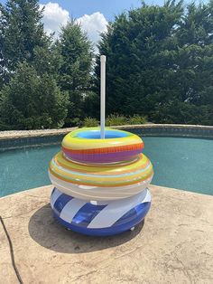 an inflatable pool float sitting on the edge of a swimming pool with trees in the background