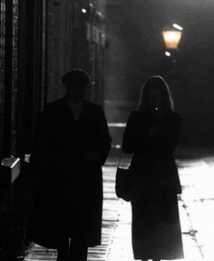 two people walking down the street at night