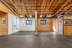 an empty room with wood paneling and exposed ceiling, in the middle of a building