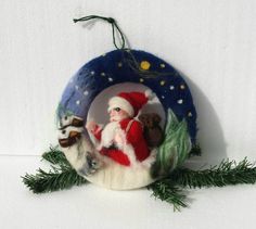 an ornament with a santa clause and two small animals