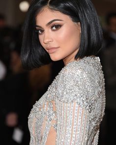 an image of a woman with black hair wearing a silver dress at the met ball