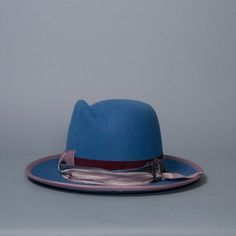 Western weight fedora with sculpted crown and upturned brim. Trimmed with mix-match grosgrain band and bow, silk sari ribbon and vintage silver buckle. Brim edge is bound with mauve grosgrain. Materials: Ethically sourced 160 g rabbit fur felt, Grosgrain, Silk, Metal Style: Western Fedora Measurements: Crown height at center front 5 in (13 cm) Brim 3 in (7.5 cm) Hat Box: 16 in How to Wear: Classic fit Ready to ship in a size 22.5 in / 57 cm / men's 7-1/8 with slightly-wider oval profile. One of Sari Ribbon, Crown Heights, Hat Box, Silk Sari, Rabbit Fur, Metal Style, Slate Blue, Mix Match, Vintage Silver