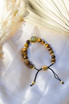 Amplify spiritual and psychic protection, and protect your personal power with our Solar Plexus Chakra Tiger's Eye Energy Protection and Psychic Power Bracelet. The Solar Plexus Chakra, also known as the Manipura Chakra, is in the pit of the abdomen, above the navel. It is responsible for personal strength and will; it is where the essence of confidence andidentity is embedded. When the Solar Plexus Chakra is awakened, the energy flows freely, clearing any self-doubt and insecurity, kindling int Adjustable Spiritual Evil Eye Bracelet For Meditation, Gold Spiritual Crystal Bracelet, Adjustable Natural Stones Rosary Bracelet For Meditation, Holistic Gold Bracelets With Natural Stones, Resizable Spiritual Bracelets, Adjustable Rosary Bracelet With Natural Stones For Meditation, Gold Bracelets With Natural Stones, Adjustable Gold Spiritual Crystal Bracelet, Gold Spiritual Crystal Bracelet With Natural Stones