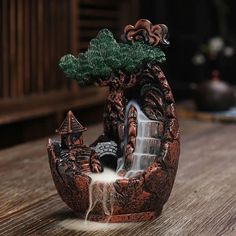 a small waterfall in the shape of a potted plant on top of a wooden table