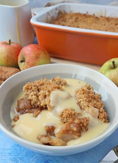 a bowl filled with food next to some apples