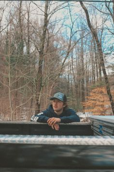 a man sitting in the back of a truck with his arms crossed and looking off into the distance