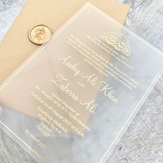 a close up of a person's hand holding an envelope with a gold seal on it