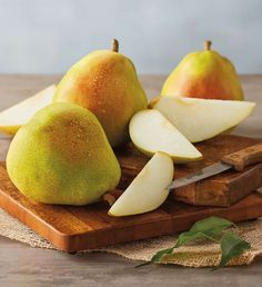 two pears and one apple on a cutting board