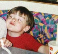 two young children sitting on a couch next to each other