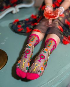 Our Cocktail Hour black sheer sock features wine glasses, martinis, and wine bottles with an unexpected olive twist. The graphic print and electrifying colors give this sock an art museum vibe, perfect for paint and sip nights with the girls. Finished with a mulberry colored cuff, heel, and toe for a sultry look. Sock Styling, Fancy Socks, Candy Cocktails, 80s Disco, Mulberry Color, Summer Sock, Pointy Heels, Sheer Socks, Pearl Jewels