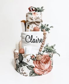 there are many items on the top of this cake that is decorated with flowers and leaves