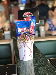 a cup filled with candy and snacks sitting on top of a counter next to a bar