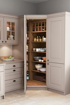 an open cabinet in the middle of a kitchen with lots of cupboards and drawers