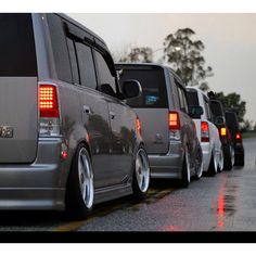 a row of cars parked on the side of a road in front of another car