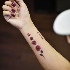 a woman's arm with red roses on it