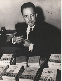 a man sitting at a table full of books