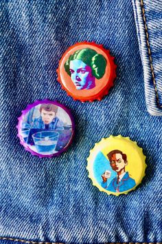 three buttons with pictures of elvis presley on them sitting in the back pocket of someone's jeans