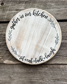 a wooden sign that says, gather in our kitchen sit at the table