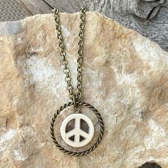 This handmade, simple, unique peace sign necklace is a great length for layering with other necklaces. It has a 1-inch, twisted circle ring with a white howlite peace sign that sits in the middle. The durable, antique brass plated rolo chain is 20 inches long with 3.0mm links and a lobster claw clasp. This versatile boho hippie necklace is perfect to pair with your bohemian outfit or with a t-shirt and jeans or give as an affordable gift. LENGTH: 20 inches I ship fast, package carefully, and am Bohemian Peace Sign Necklace For Gift, Symbolic Round Peace Sign Jewelry, Vintage Jewelry With Peace Sign For Gift, Vintage Jewelry With Peace Sign As Gift, Vintage Peace Sign Jewelry Gift, Adjustable Peace Sign Necklace As Gift, Adjustable Peace Sign Necklace, Spiritual Peace Sign Necklace As A Gift, Adjustable Spiritual Jewelry With Peace Sign