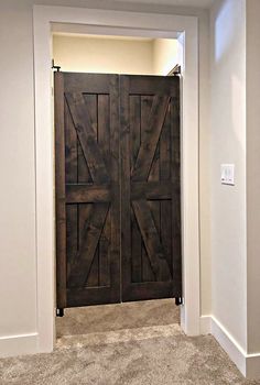 an open wooden door in the middle of a white room with carpet on the floor