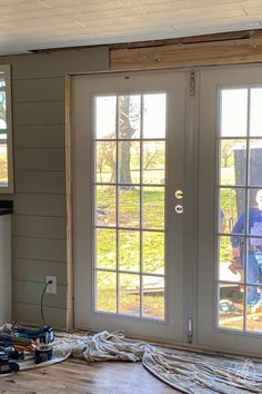 the inside of a house being remodeled with construction materials on the floor and two windows