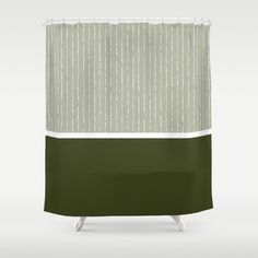 a green and white shower curtain with vertical stripes on the bottom, in front of a gray background