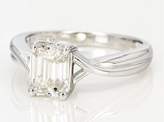 an emerald - cut diamond ring is shown on a white surface, with a twisted band around it