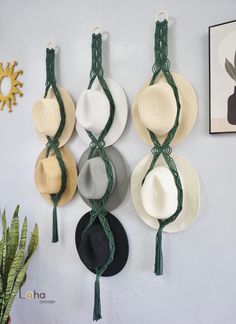 hats are hung on the wall with green string