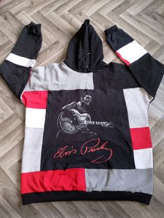 Elvis Presley rework hoodie. This stunning hoodie has been created using preloved hoodies, sweatshirts and a Elvis Presley t shirt. The colours used are black, grey, red and white. This unique one of a kind hoodie is part of my new sustainable fashion brand...you will not find anything like it on the high street. As the name suggests, reworked clothing is the process of taking vintage or pre-loved garments and transforming them into new, one-of-a-kind pieces. This not only gives a new lease of l Retro Patchwork Sweatshirt For Streetwear, Retro Black Long Sleeve Hoodie, Black Long Sleeve Retro Hoodie, Retro Black Cotton Hoodie, Retro Black Hoodie Sweatshirt, Black Retro Cotton Hoodie, Black Cotton Retro Hoodie, Reworked Sweatshirts, Reworked Hoodie