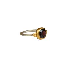 This handcrafted ring features a deep red garnet, elegantly set in a rich gold bezel, beautifully contrasting with the slender silver band. The delicate gold accents on either side of the garnet add a playful touch, creating a more casual feel. This piece can easily be combined with a casual oufit or really be accentuated by combining it with a red or black cocktail dress. Sterling silver  Gold vermeil  Garnet  To properly care for your silver jewellery, there are a few important steps you should follow: Clean the jewellery regularly to prevent tarnishing and discoloration. Use a mild detergent or special silver matting sponge. Gently rub the jewellery to remove dirt and oxidation. Avoid gold-plated surfaces so that they do not rub off the gold layer. Avoid contact with chemicals such as p Fine Jewelry Garnet Ruby Ring With Bezel Setting, Elegant Garnet Gemstone Stackable Rings, Elegant Stackable Garnet Gemstone Rings, Elegant Garnet Stackable Rings, Heirloom Garnet Jewelry With Bezel Setting, Heirloom Garnet Ring With Bezel Setting, Elegant Red Garnet Stackable Rings, Elegant Stackable Garnet Jewelry, Elegant Garnet Ring With Bezel Setting