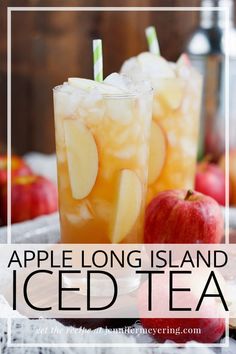 two glasses filled with iced tea sitting on top of a table next to an apple