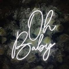 the words oh baby are lit up in front of flowers