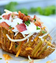 a baked potato topped with bacon, cheese and parmesan on a white plate