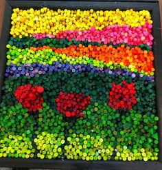 there are many different colored buttons on the table and one is made out of bottle caps