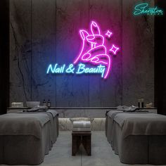 a neon sign that says nail & beauty in front of two tables with gray linens