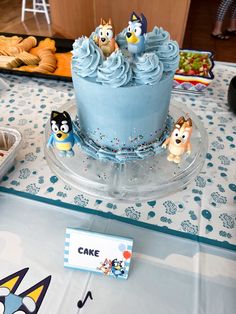 a blue cake sitting on top of a table