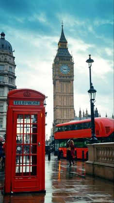 the big ben clock tower towering over the city of london and red telephone booths in the rain